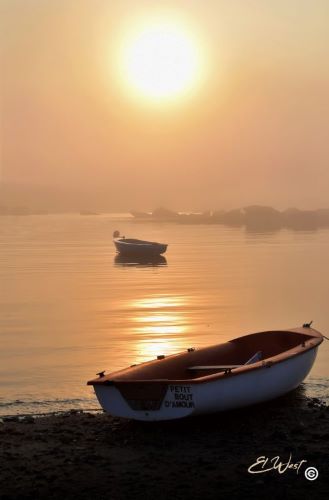 Brouillard devant un coucher de soleil au port de Melon- Porspoder. Tons orangés. Une barque sur les galets et une autre sur une mer apaisée. Finistère- Bretagne- France