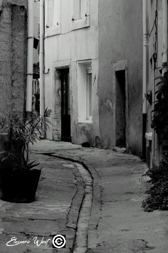 Ruelle étroite à Sigean- Aude- Occitanie- France - Caniveau au centre de l'impasse Photo noir & blanc