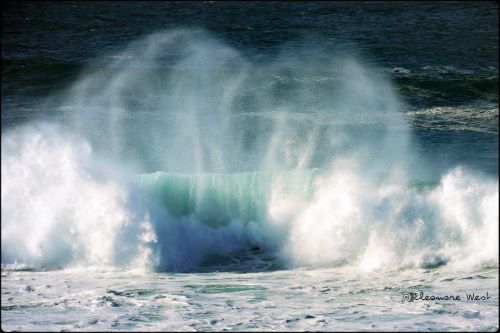 Sur une vague rouleau turquoise qui s'écrase, l'écume légère dessine un coeur.
